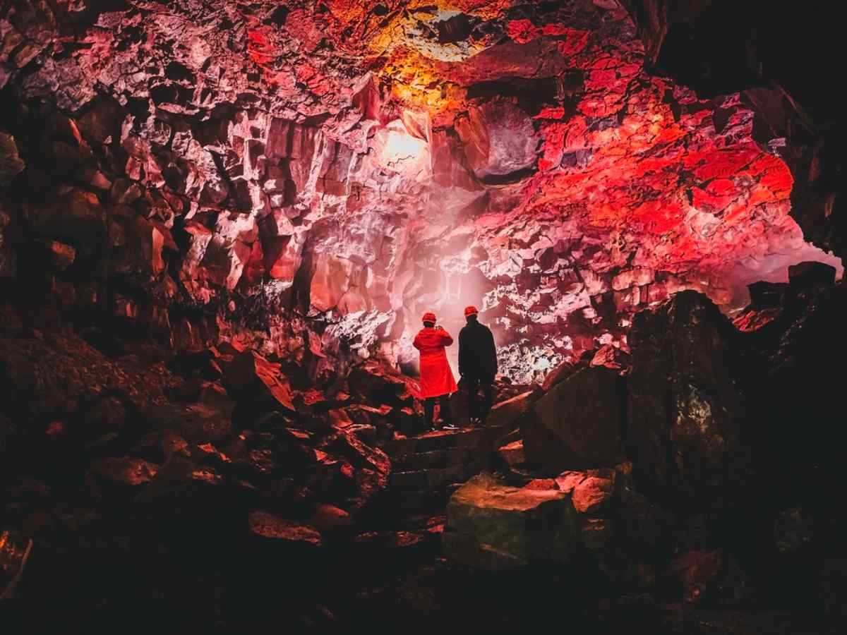 Lava cave tunnel with two tourists inside