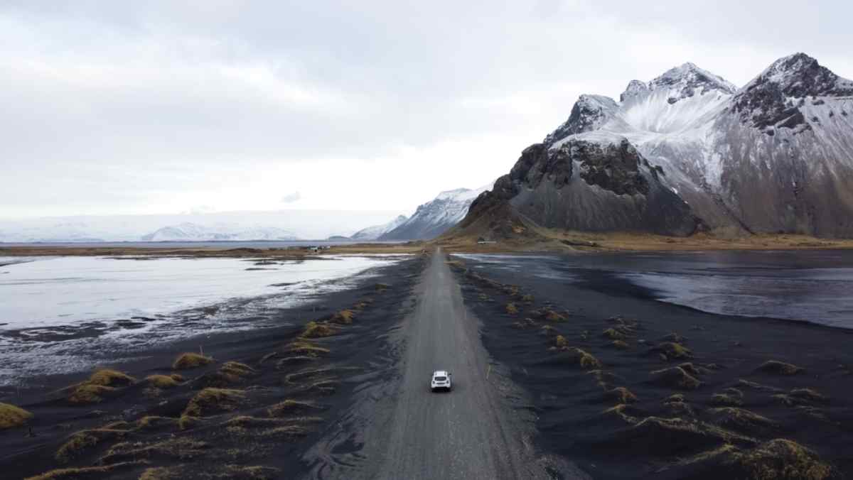 Aerial view of Vestrahorn mountain with snow and a car on the road
