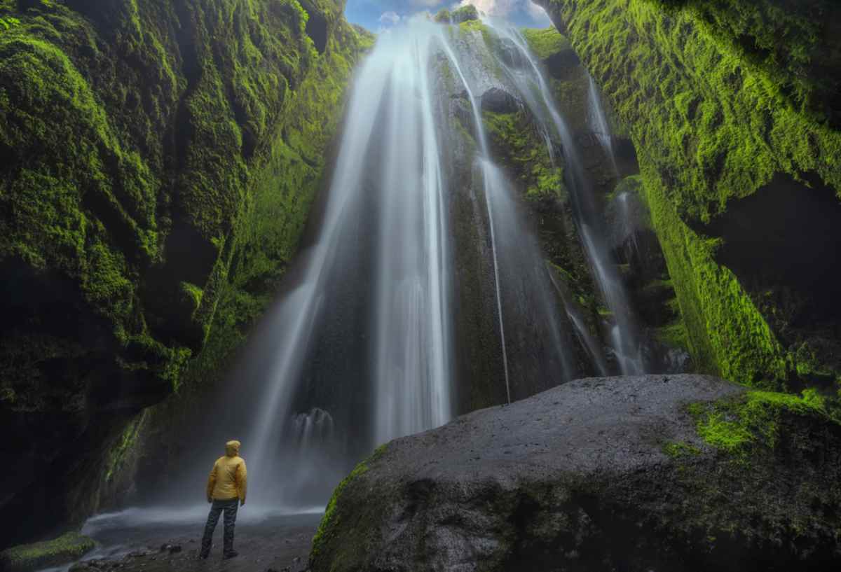 Hiker by a waterfall in stakkholtsgj&aacute;