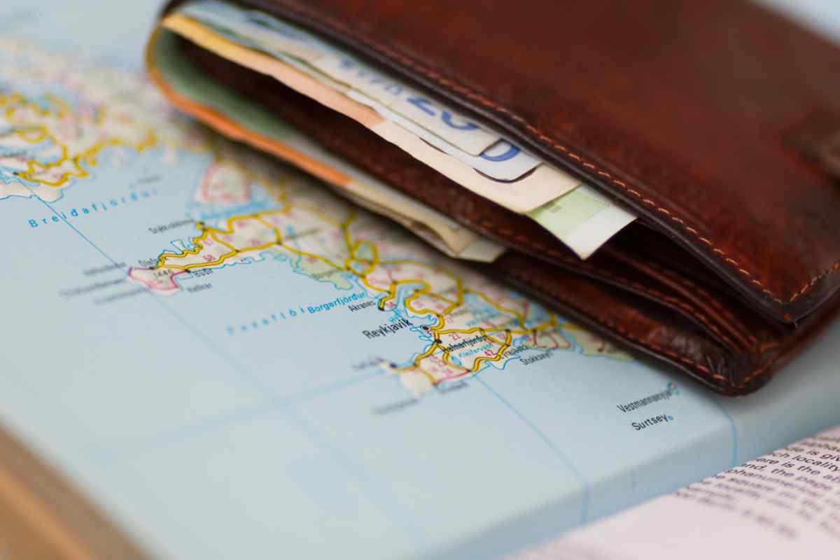 Icelandic map and money A closed wallet with several Icelandic kroner sticking out sits on a paper map of Iceland.