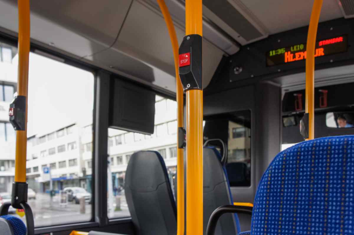 Public transportation in Iceland Interior of a Reykjavik city and public bus with multiple windows, a particular orange color inside and information screens.
