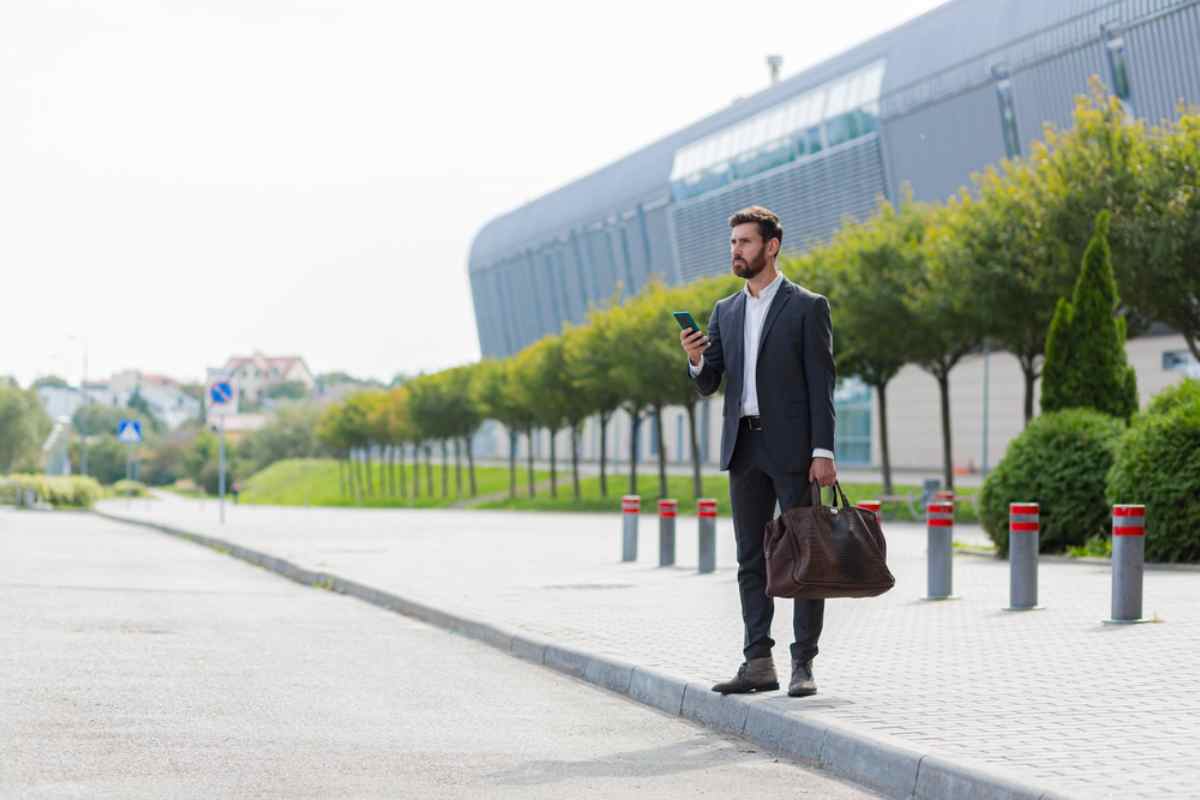 Why Uber is not in Iceland A man in a suit with a briefcase in his left hand stares in one direction while holding his cell phone in his right hand