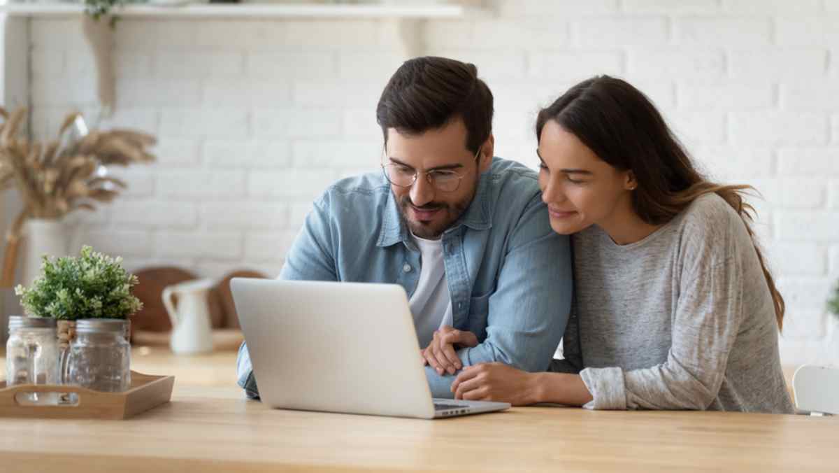 When to reserve a car seat A young couple consisting of a bearded man and a woman look at their computer screen.