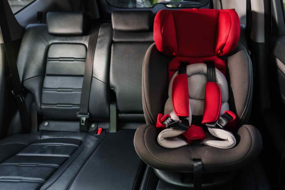 Different types of car seats A child car seat remains next to a conventional seat in the rear of a vehicle.