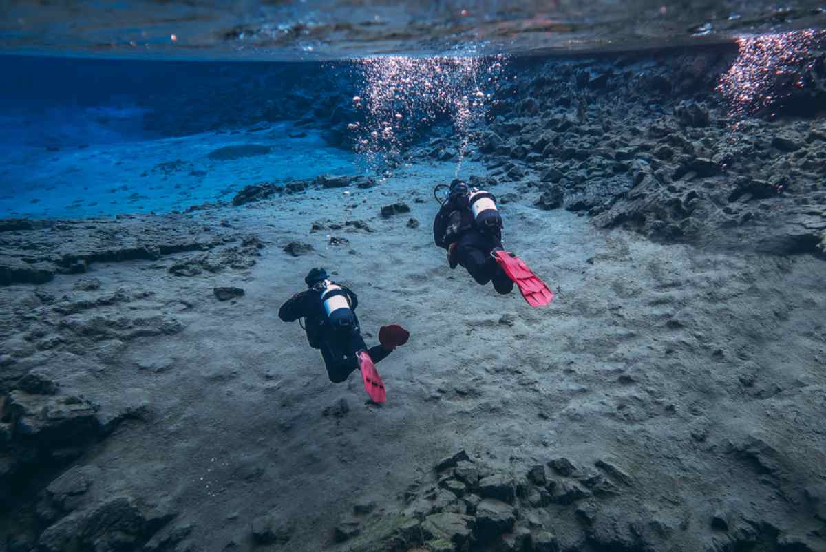 Two divers visit the Silfra fissure in Iceland on what looks like a snorkeling excursion. 