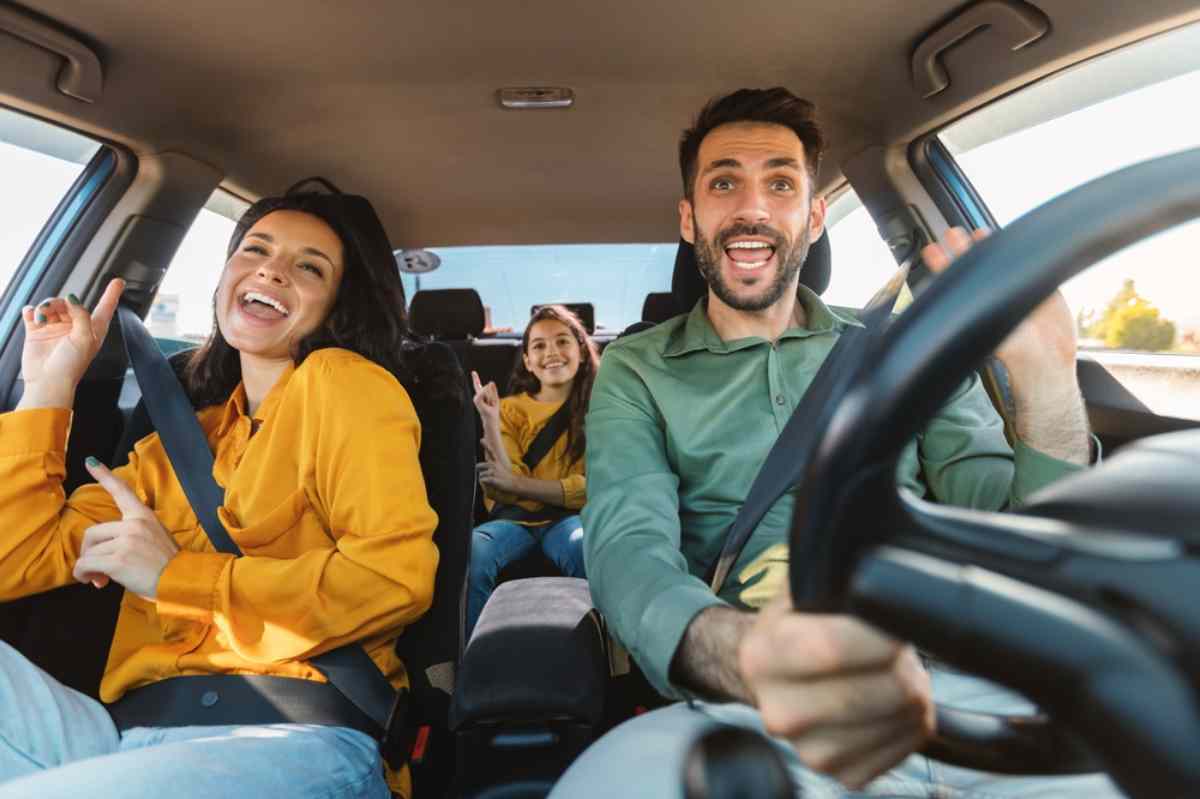 Happy family singing and laughing together inside a car during a road trip Family having fun in the car