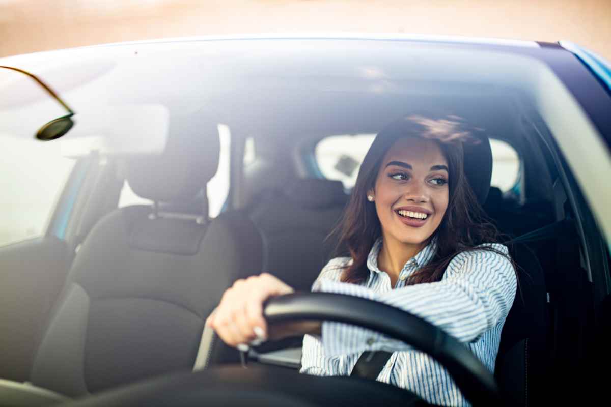 Happy young woman behind the wheel enjoying her rental car in Iceland.