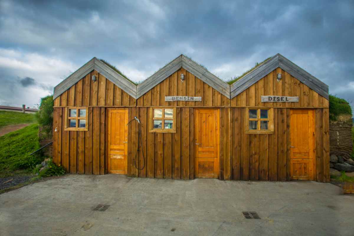 Traditional wooden shed labeled for gasoline and diesel in rural Iceland.