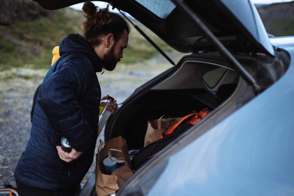 Packing tips to drive in Iceland Camper loading groceries and gear into a car trunk during an Iceland road trip.